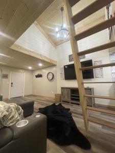 a living room with a couch and a clock at Catch'em AK - Bears Den in Soldotna