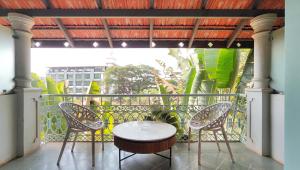 a patio with a table and chairs on a balcony at Plot 77 by hnh in Baga +119 photos