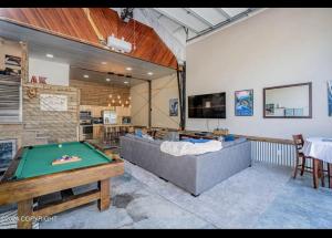 a living room with a couch and a pool table at Catch'em AK - Eagles Nest in Soldotna