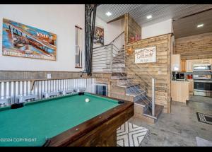 a room with a pool table and a staircase at Catch'em AK - Eagles Nest in Soldotna