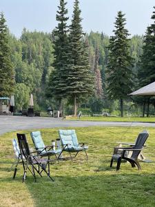 three chairs and a table in the grass at Catch'em AK - Salmon Cove in Soldotna