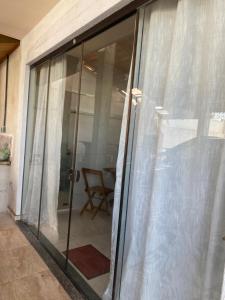 a sliding glass door with white curtains on it at Studio sattwa 2 in Prudentópolis