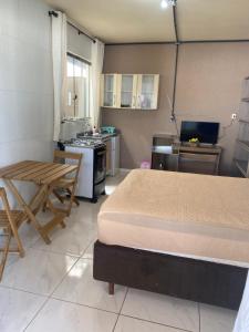 a room with two beds and a kitchen with a table at Studio sattwa 2 in Prudentópolis
