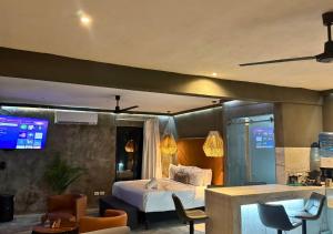 a hotel room with a bed and tables and chairs at Rico Isla Rooms Eco-Chic in Isla Mujeres