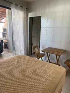 a bedroom with a bed and a table and a chair at Studio sattwa 2 in Prudentópolis