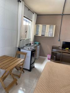 a small kitchen with a stove and a table at Studio sattwa 2 in Prudentópolis