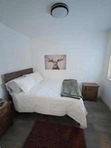 a bedroom with a white bed with a picture on the wall at Seward Mountain View Cabins #6 in Seward +10 photos