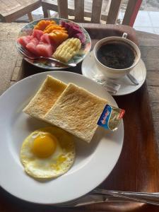 a plate with an egg and corn and a cup of coffee at Pantai Ayu Homestay in Padangbai