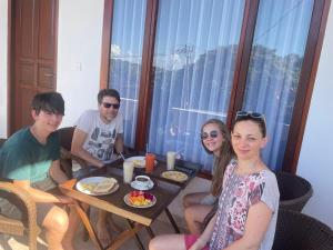 a group of people sitting around a table eating food at Pantai Ayu Homestay in Padangbai