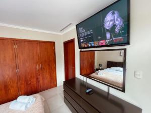 a bedroom with a bed and a flat screen tv at Gallery Suite en Riverfront Puerto Santa Ana in Guayaquil
