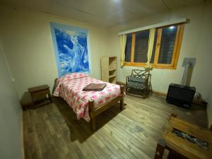 a bedroom with a bed and a television in it at ይሥሓቅ House in Puerto Natales