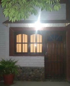 a building with a window and a door with a light at Alquiler la nona in Malargüe