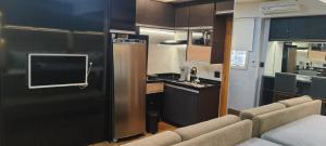 a kitchen and a living room with a tv and a couch at Apartamento Águas Claras S4 particular in Águas Claras +9 photos