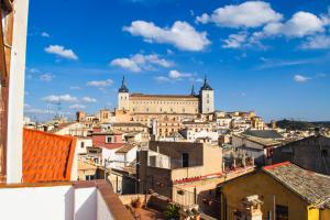 a view of a city from the roofs of buildings at Apartamentos Sal de Luna in Toledo