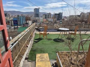 a balcony with chairs and grass on a city at Gana's Guest House and Tours in Ulaanbaatar +53 photos