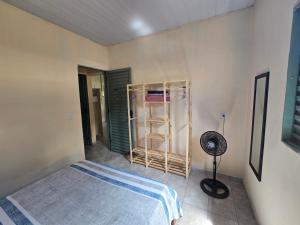 a bedroom with a bed and a fan in it at MAEVE Albergue in Goiás
