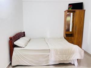 a bedroom with a bed with a mirror and a cabinet at HiDot Holidays in Padinjarathara
