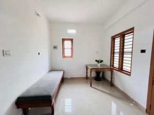 a room with a bed and a table at HiDot Holidays in Padinjarathara