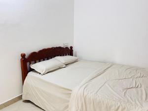 a bed with two pillows on it in a room at HiDot Holidays in Padinjarathara +2 photos