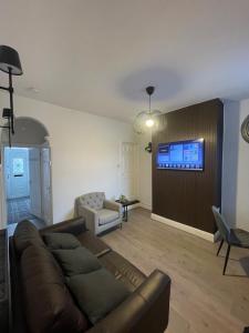 a living room with a couch and a tv on a wall at Modern Homes in Stoke on Trent
