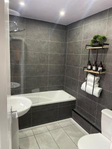 a bathroom with a tub and a toilet and a sink at Modern Homes in Stoke on Trent