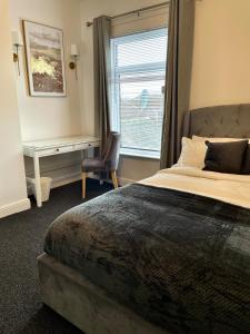 a bedroom with a bed and a desk and a window at Modern Homes in Stoke on Trent