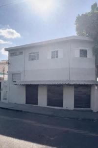 a white building with four garage doors on a street at CasaMara in Ribeirão Preto