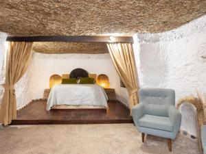 a bedroom with a bed and a chair at La cueva del marinero in El Socorro