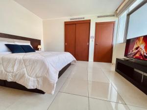 a bedroom with a bed and a flat screen tv at Suite frente al río en Puerto Santa Ana Riverfront in Guayaquil