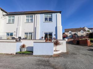 a white house with a table in front of it at Corvette in Trearddur
