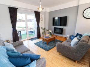 a living room with two couches and a tv at Corvette in Trearddur