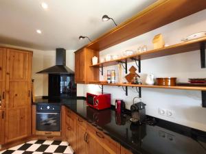 a kitchen with black counter tops and wooden cabinets at AC Apartaments Apollo Soldeu in Soldeu
