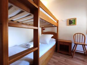 a bedroom with two bunk beds and a chair at AC Apartaments Apollo Soldeu in Soldeu