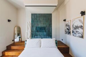 a bedroom with a white bed and a blue wall at Palazzo Italia Suites in Bari