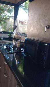 a kitchen counter with a stove and a microwave at Casa D a 2 - Con Parrilla - Centro de Federación in Federación