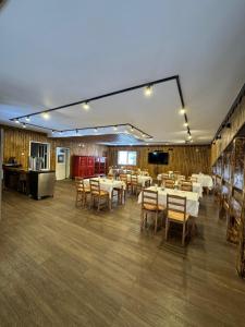 a dining room with tables and chairs and a kitchen at POARTA PADINA, statiunea Pestera-Padina, Bucegi in Moroeni +19 photos