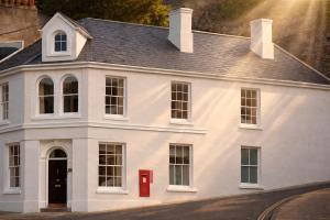 a white house with a red post box in front at The Old Post Office - Parking Available - 75 meters Estuary in Salcombe