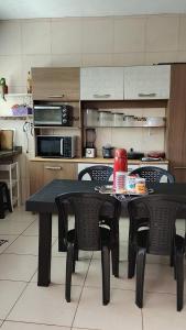 a kitchen with a table and chairs in a kitchen at Casa da Mari in Caucaia