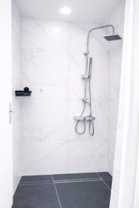 a bathroom with a shower with white marble walls at baadenbergerstay A in Cologne +9 photos