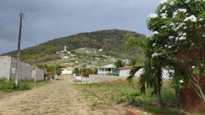 a street in a village with a mountain in the background at Casa da Mari in Caucaia