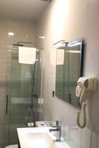 a bathroom with a phone on the wall next to a sink at Apartamentos Sal de Luna in Toledo +60 photos