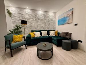 a living room with a green couch and two chairs at Holiday Apartment Lira jacuzzi - sea view- terrace in Mlini