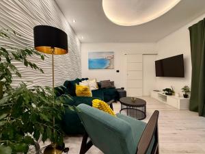 a living room with a green couch and a tv at Holiday Apartment Lira jacuzzi - sea view- terrace in Mlini