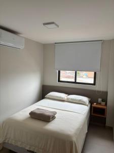 a bedroom with a large white bed with a window at Apto 2 Quartos Novo e Super Confortável in Arapiraca