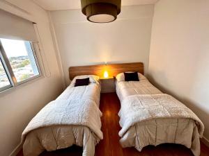 two beds in a small room with a window at Urbano Alem in Coronel Suárez