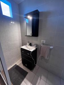 a bathroom with a sink and a shower with a mirror at Urbano Alem in Coronel Suárez +10 photos