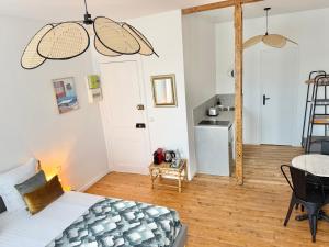 a bedroom with a bed and a kitchen with a table at Résidence Gaïa - Etretat in Étretat