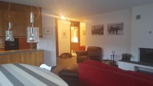 ein Wohnzimmer mit einem roten Sofa und einer Küche in der Unterkunft Casa Alva in Flims