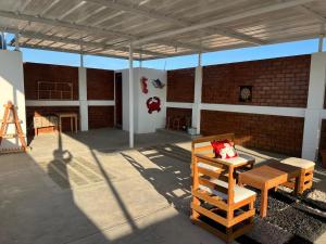 a patio with a wooden bench and a brick building at Hospedaje Wendy in Puerto Chicama