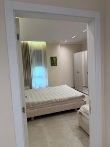a bedroom with a bed and a large window at Tirana Urban Nest in Tirana